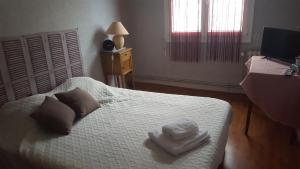 1 dormitorio con 1 cama con 2 toallas en HOTEL RESTAURANT Bar LA KAHINA, en Chouzé-sur-Loire
