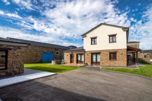a large brick house with a driveway at Apartamentos Rurales Lola Penarronda in Castropol