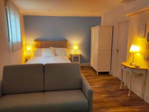 a bedroom with a bed and a couch and two lamps at AT La casa Azul in Cuenca