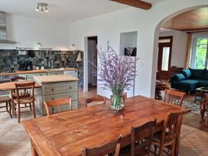 una cucina e una sala da pranzo con un tavolo in legno con fiori di Grande maison escapade au bord de la riviere a Touvre