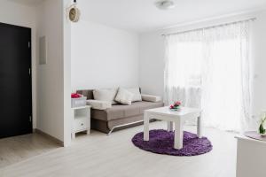 - un salon blanc avec un canapé et une table dans l'établissement Apartment Andrej, à Tomislavgrad