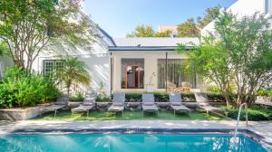 a backyard with a pool and chairs and a house at Oude Werf Hotel in Stellenbosch