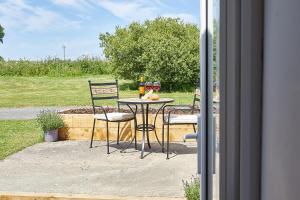 a table with two chairs and two glasses of wine at Host & Stay - The Pepper Pot in Alnwick