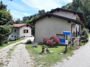 una piccola casa bianca con una recinzione accanto di Natura e relax a Barge