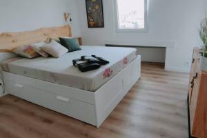 a large white bed in a room with wooden floors at Petit loft sur les toits d'Avignon in Avignon