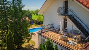 - un balcon d'une maison avec une piscine dans l'établissement Bryza Jantar apartamenty z sauną & domki z kominkami, à Jantar