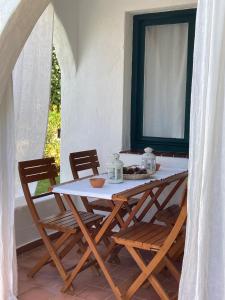 Apartamento a 25 metros del mar في Binisafua: طاولة وكراسي في غرفة مع نافذة
