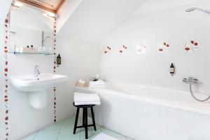 a bathroom with a sink and a tub and a toilet at Boutique Hotel Bristol in Košice