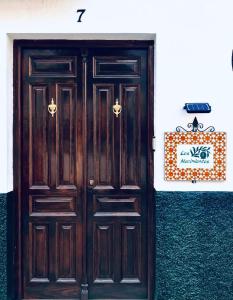 parę drewnianych drzwi na boku budynku w obiekcie Vivienda rural “Los Nacimientos” w mieście Alhama de Granada