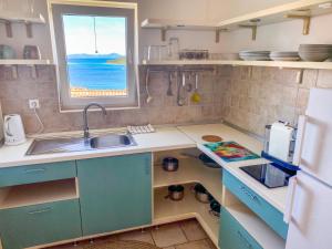 a small kitchen with a sink and a window at Eco Sunshine Apartments Lumbarda in Lumbarda