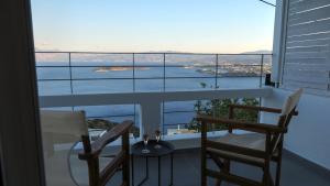 a balcony with two chairs and a view of the ocean at Villa Veranda Agios NIkolaos (suite) in Agios Nikolaos