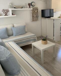 Apartamento a 25 metros del mar في Binisafua: غرفة معيشة مع أريكة وطاولة