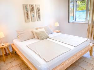 a large white bed in a room with two lamps at Eco Sunshine Apartments Lumbarda in Lumbarda