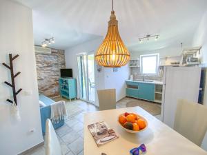 a kitchen and dining room with a bowl of fruit on a table at Eco Sunshine Apartments Lumbarda in Lumbarda