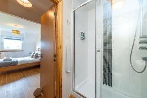 a bathroom with a shower with a glass door at Lazy Puffin in Stonehaven