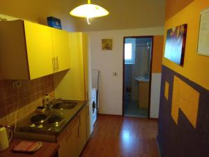 una cocina con armarios amarillos y fregadero en Apartment Doris en Rijeka