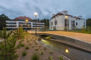 un ponte su un fiume di fronte a un edificio di Apartament Baltica z Tarasem - tuż przy plaży - dwupoziomowy a Rogowo