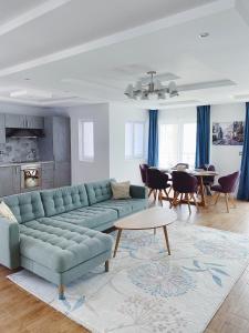 ein Wohnzimmer mit einem blauen Sofa und einem Tisch in der Unterkunft Amanito Apartments in Prčanj