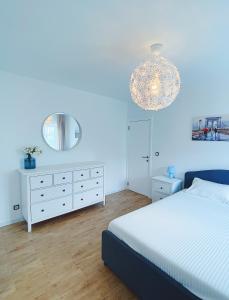 a bedroom with a white bed and a chandelier at Amanito Apartments in Prčanj