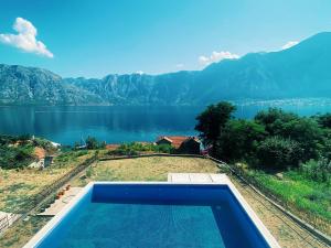 a swimming pool with a view of a lake at Amanito Apartments in Prčanj