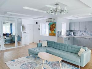 a living room with a blue couch and a kitchen at Amanito Apartments in Prčanj