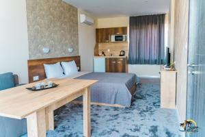 a hotel room with a bed and a wooden table at Gradina Holiday in Sozopol