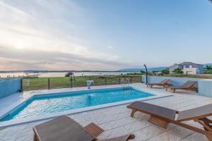 een zwembad met een tafel en stoelen op een patio bij Kuća za odmor in Privlaka +25 foto's