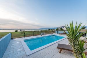 een zwembad op een patio met uitzicht op het water bij Kuća za odmor in Privlaka