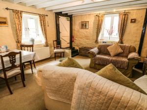 un soggiorno con divano e tavolo di Rose Cottage a Yelverton