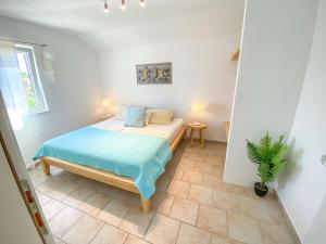 a bedroom with a bed and a potted plant at Eco Sunshine Apartments Lumbarda in Lumbarda +37 photos