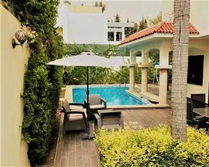 - une terrasse avec un parasol à côté de la piscine dans l'établissement Riad Sebti Fès, à Fès