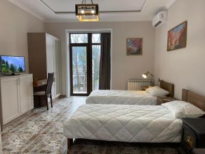 a bedroom with two beds and a desk and a television at Кайзервальд Клуб in Karpaty +60 photos