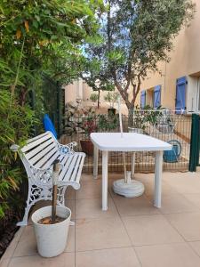 a white table and two chairs sitting next to a table at CHAMBRE A LEUCATE VILLAGE in Leucate