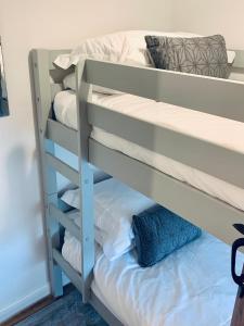 a bunk bed with white pillows and a blue pillow at The Tenth House, Grade II Listed Georgian Town House, Wirksworth, Derbyshire, Peak District Cottage, Sleeps 4 in Wirksworth