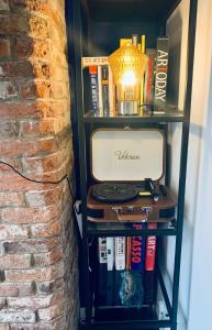 a book shelf next to a brick wall at The Tenth House, Grade II Listed Georgian Town House, Wirksworth, Derbyshire, Peak District Cottage, Sleeps 5 in Wirksworth