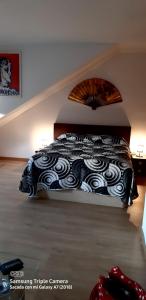 a bed with a black and white comforter in a room at Tomillaron House in Las Rozas de Madrid