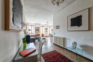 een woonkamer met een tafel en een tv aan de muur bij Royal Rialto Apartment - Grand Canal View in Venetië +35 foto's