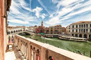een uitzicht vanaf een brug over een rivier met boten bij Royal Rialto Apartment - Grand Canal View in Venetië