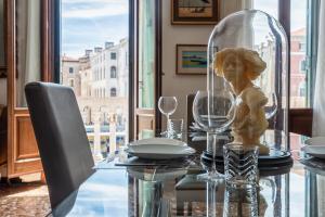 a table with a statue of a woman in a glass dome at Royal Rialto Apartment - Grand Canal View in Venice
