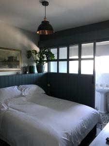 Un dormitorio con una gran cama blanca y una ventana en Raymond House B&B Penally, Tenby, en Penally