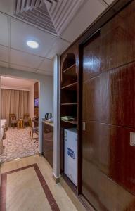 Habitación con una gran puerta de madera y una sala de estar. en Jiwar Al Madina Hotel en Medina