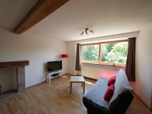 - un salon avec un canapé et une fenêtre dans l'établissement Appartement T2 40m2 avec extérieur 4 couchages, à Saint-Bonnet-en-Champsaur
