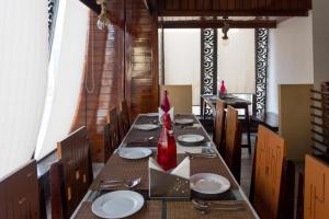un comedor con una mesa larga con platos y sillas en Hotel Hari Vilaas, en Varanasi