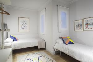 バルセロナにあるOla Living Brotoの白い壁の客室内のベッド2台