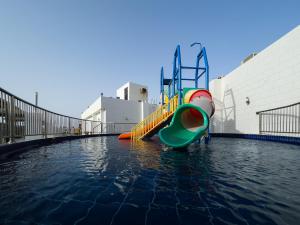 un parque infantil con un tobogán en el agua en Sand Beach Suites(Families only), en Rayyis