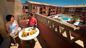 een man en vrouw op een balkon met een fruitschaal bij Leo Enebrales in Punta Umbría