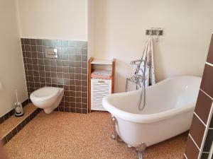 a bathroom with a white tub and a toilet at Modernes wohnen im alten Beelitz Wohnung 1 in Beelitz +10 photos