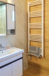 a bathroom with a sink and a towel rack at Villa Goliku in Peshtan