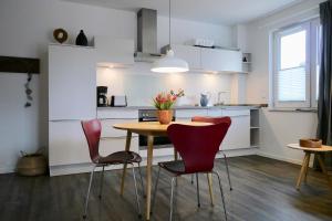 a kitchen with a table and chairs in a room at Am Ring 22 Whg 4 Kormoran in Kellenhusen