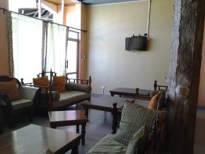 a living room with couches and tables and a tv at Midview Hotel Nyali in Mombasa